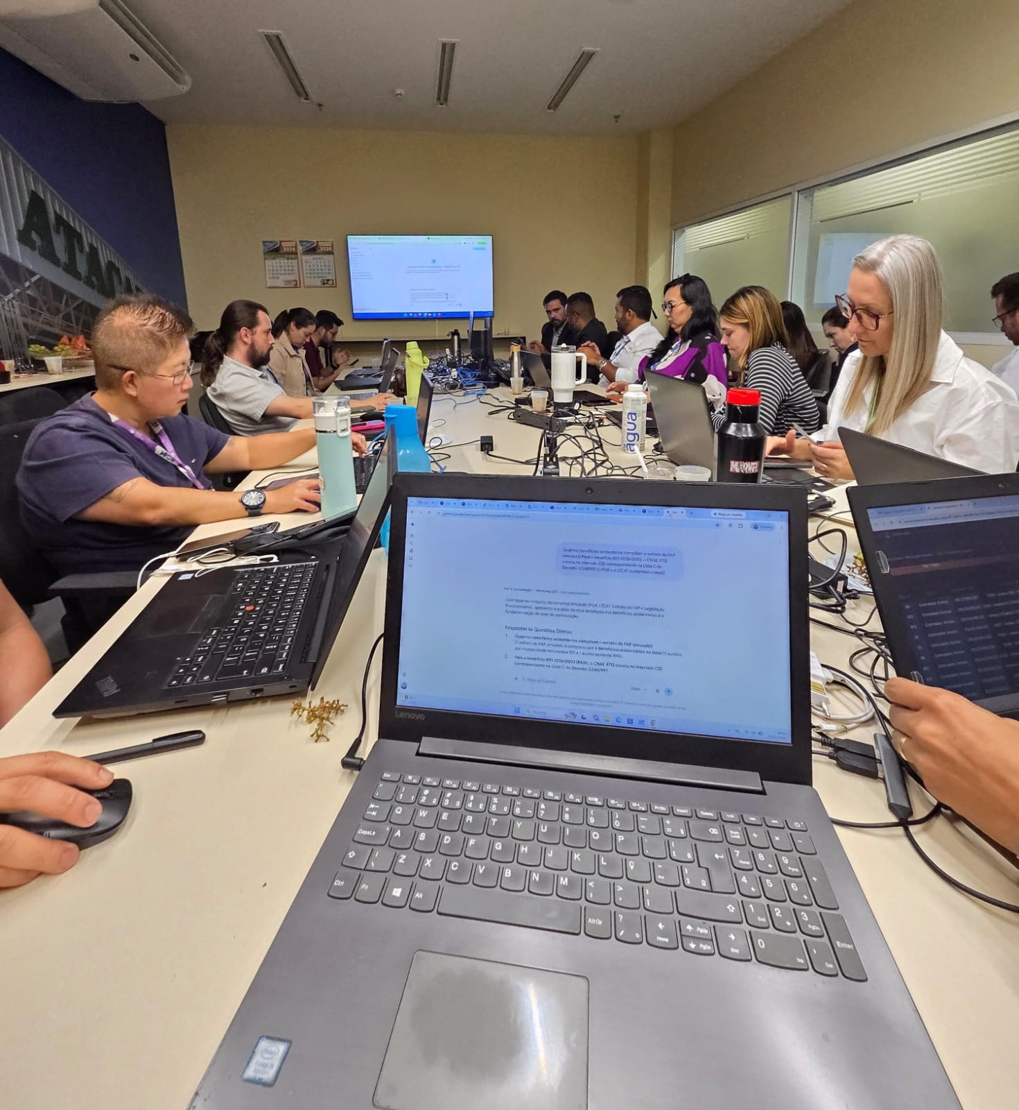 Equipe de profissionais realizando prática guiada com notebooks durante capacitação